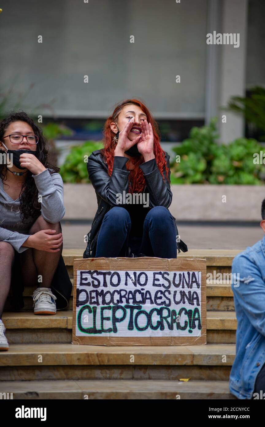 Bogota, Colombia. 23rd Aug, 2020. A demonstrator shouts with a sign that reads in spanish 'This is not a democracy, this is a Cleptocracy' during the Memorial Demonstrations for Dilan Cruz on August 23 2020 in Bogota, Colombia. Dilan Cruz was a high school student who was shot by a riot police officer during the 2019 national strike in Colombia, on the demonstrations that took place on november 23 2019. (Photo by Sebastian Barros Salamanca/Pacific Press) Credit: Pacific Press Media Production Corp./Alamy Live News Stock Photo