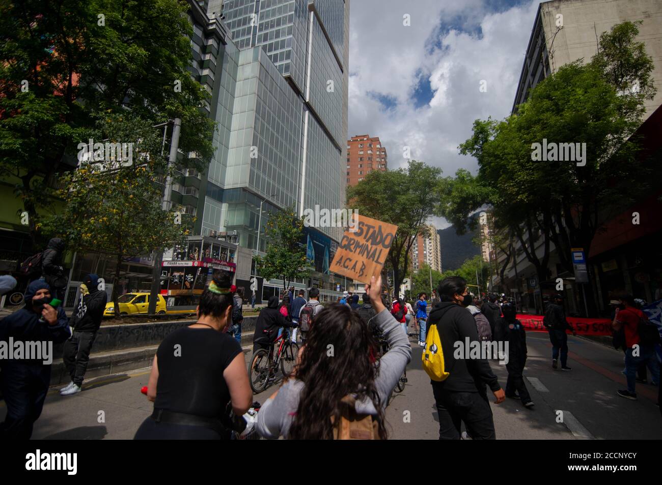 Bogota, Colombia. 23rd Aug, 2020. A demonstrator holds a sign that reads 'The goverment is criminal' during the Memorial Demonstrations for Dilan Cruz on August 23 2020 in Bogota, Colombia. Dilan Cruz was a high school student who was shot by a riot police officer during the 2019 national strike in Colombia, on the demonstrations that took place on november 23 2019. (Photo by Sebastian Barros Salamanca/Pacific Press) Credit: Pacific Press Media Production Corp./Alamy Live News Stock Photo