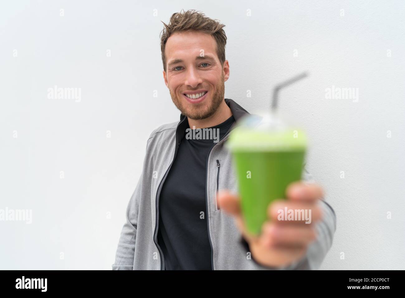 Health man drinking weight loss green smoothie. Healthy fit man happy drinking detox cleanse vegetable juice. Active lifestyle, morning breakfast Stock Photo