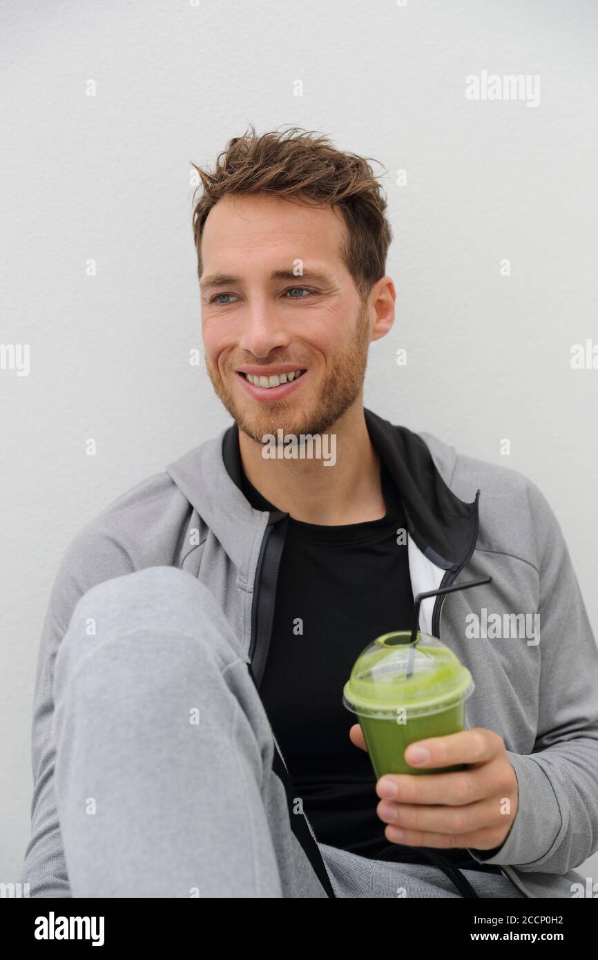 Green smoothie healthy diet man drinking detox vegetable juice cleanse. Sport athlete holding plastic cup drink for morning breakfast Stock Photo