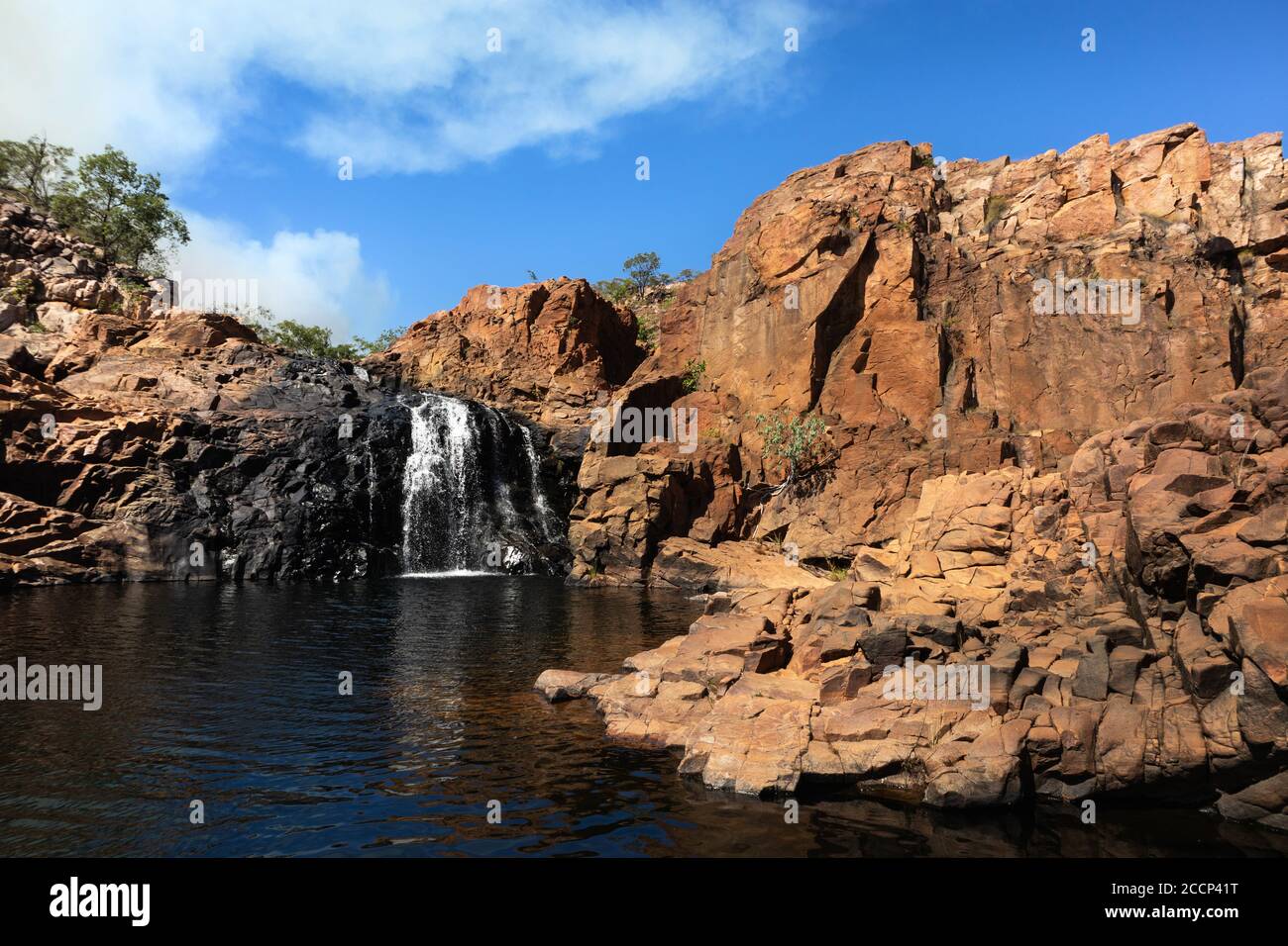 Middle pool on the trek from Edith falls to Upper pool cascades. Smoke coming from fuel burning. Black natural rock. Edith falls, Nitmiluk, Australia Stock Photo