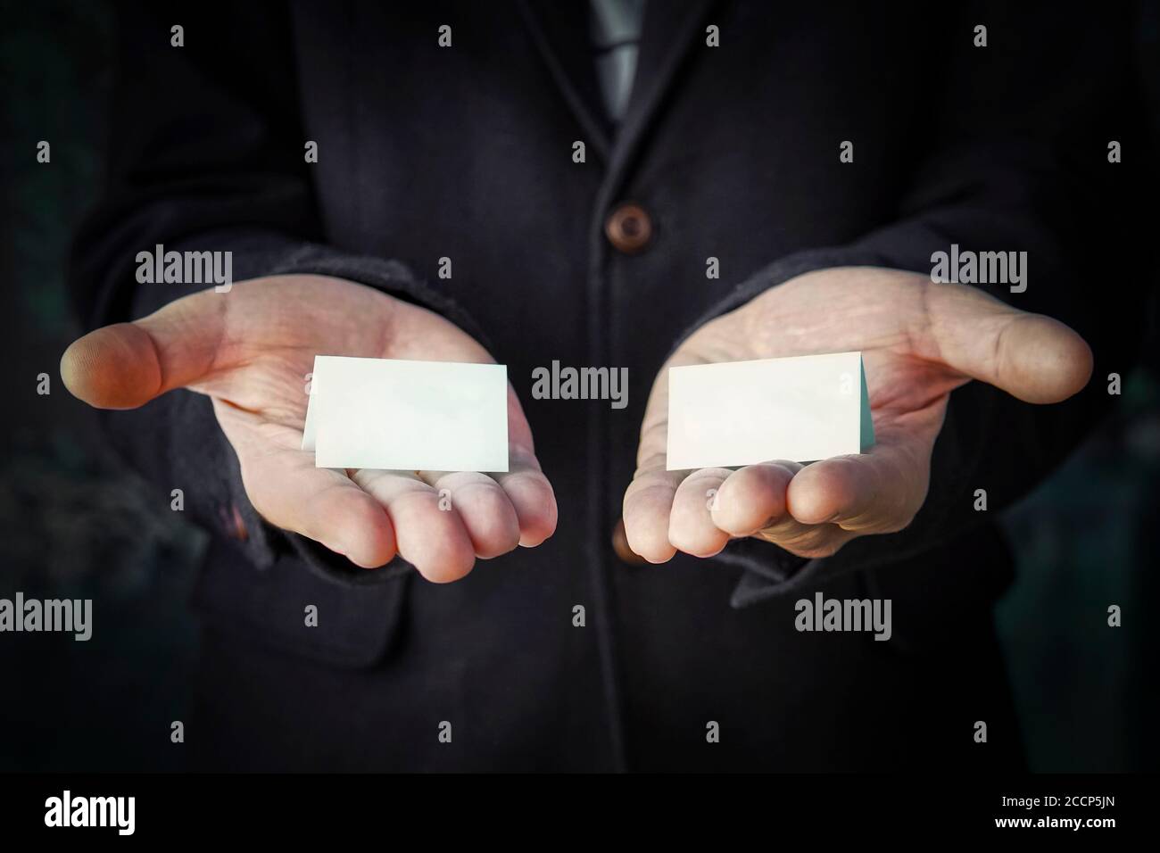 hands is holding a blue color papers with empty space for note. Offer choice of 2 options. Stock Photo