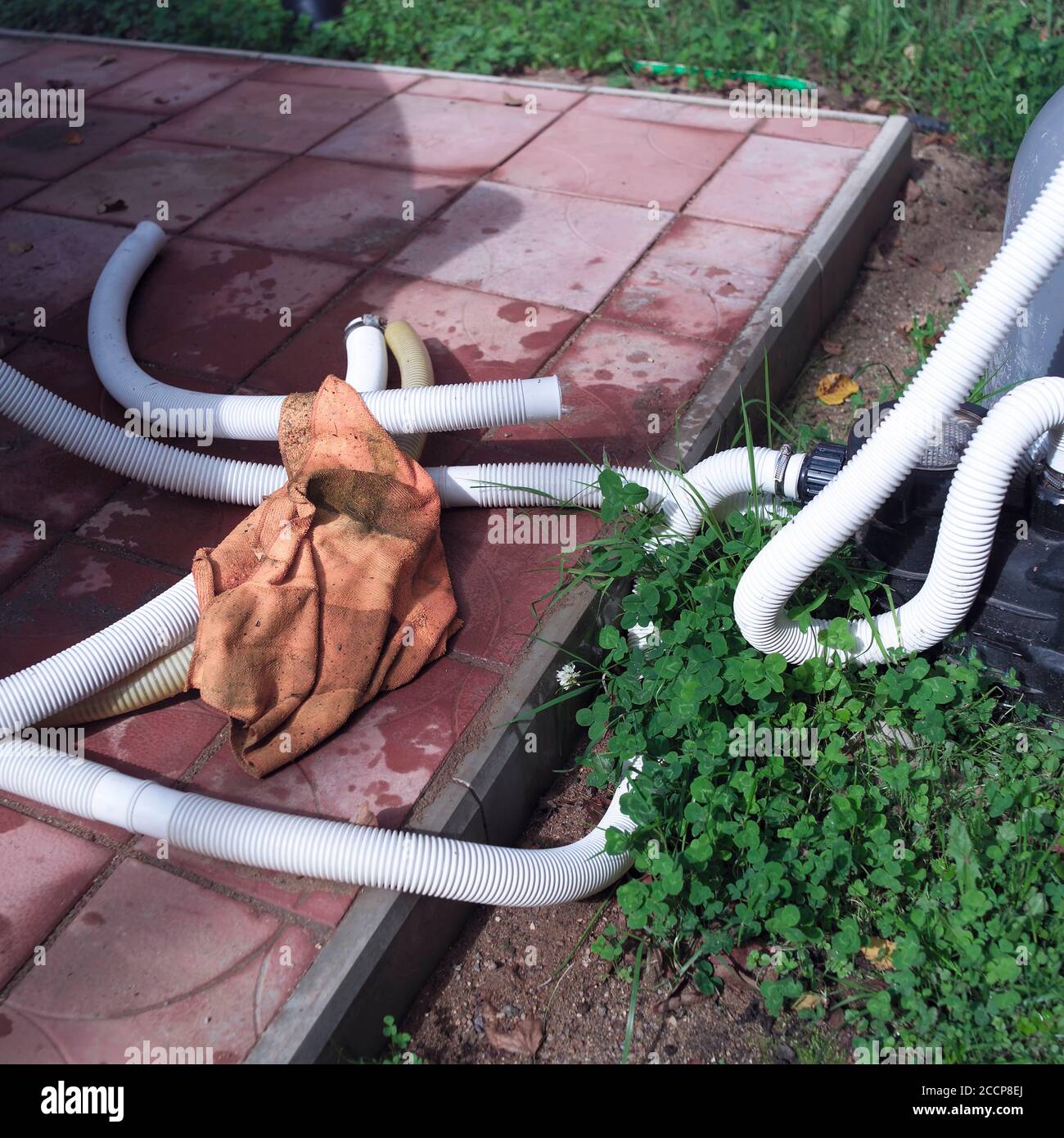 Water pump leaking and hoses spread out on the tiled floor, outdoor