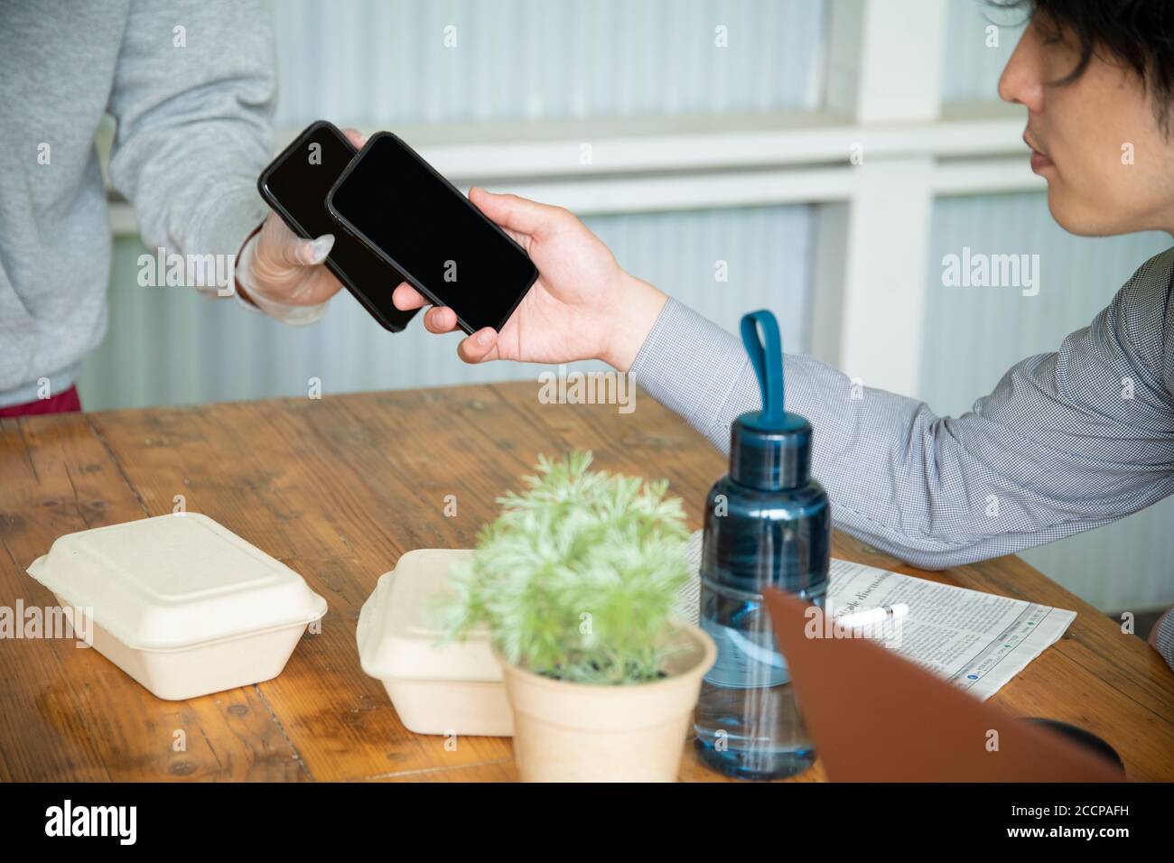 Mature Man and Delivery Person Using E-Payment Stock Photo