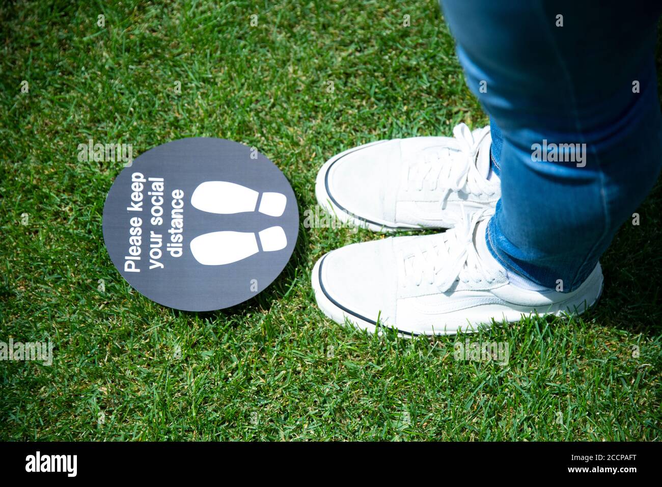 Young Man's Feet and Social Distance Sign Stock Photo - Alamy