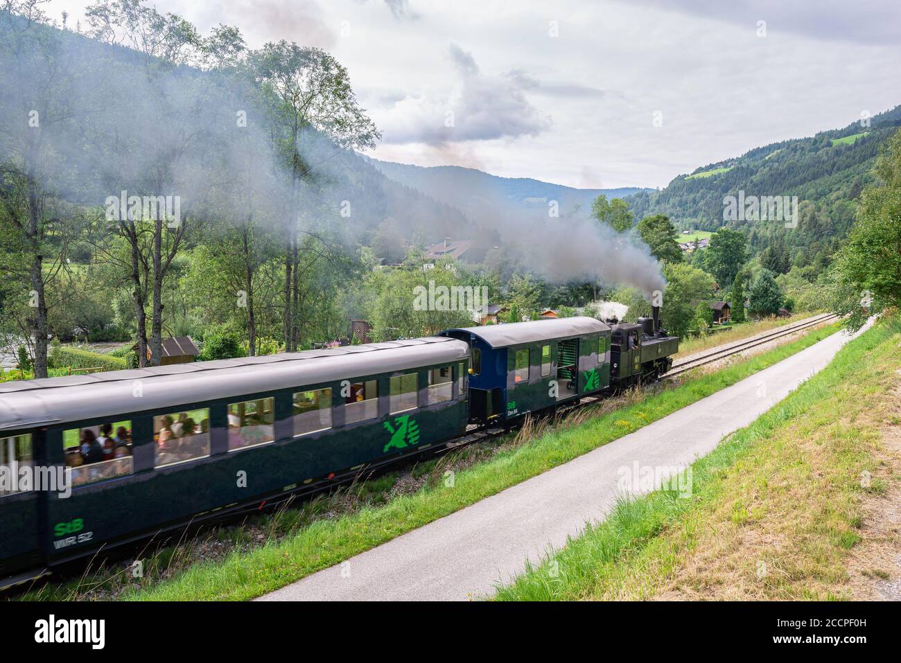 Tourist steam train 'Murtalbahn', runs between the cities of Murau and Tamsweg in Austria. Rail cars are slightly blurred from train movement. Stock Photo