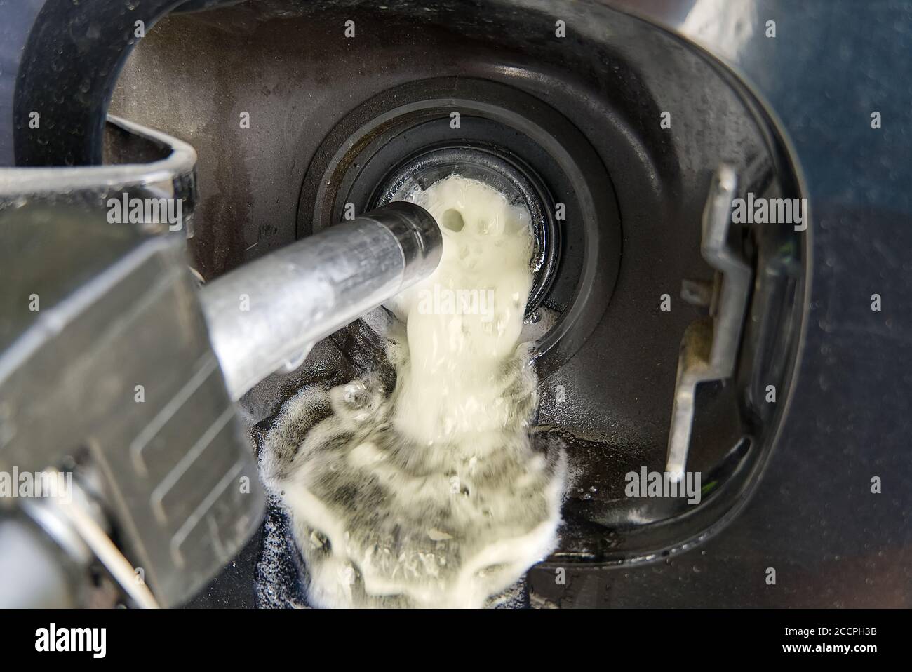 overflow of fuel when refueling a black car with diesel . not