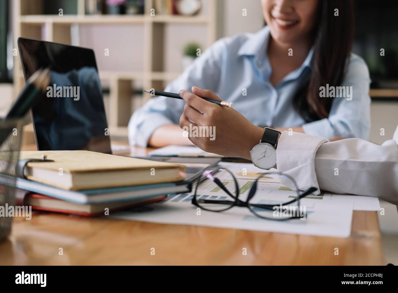 Asian business adviser meeting to analyze and discuss the situation on the financial report in the meeting room. Financial advisor and accounting Stock Photo