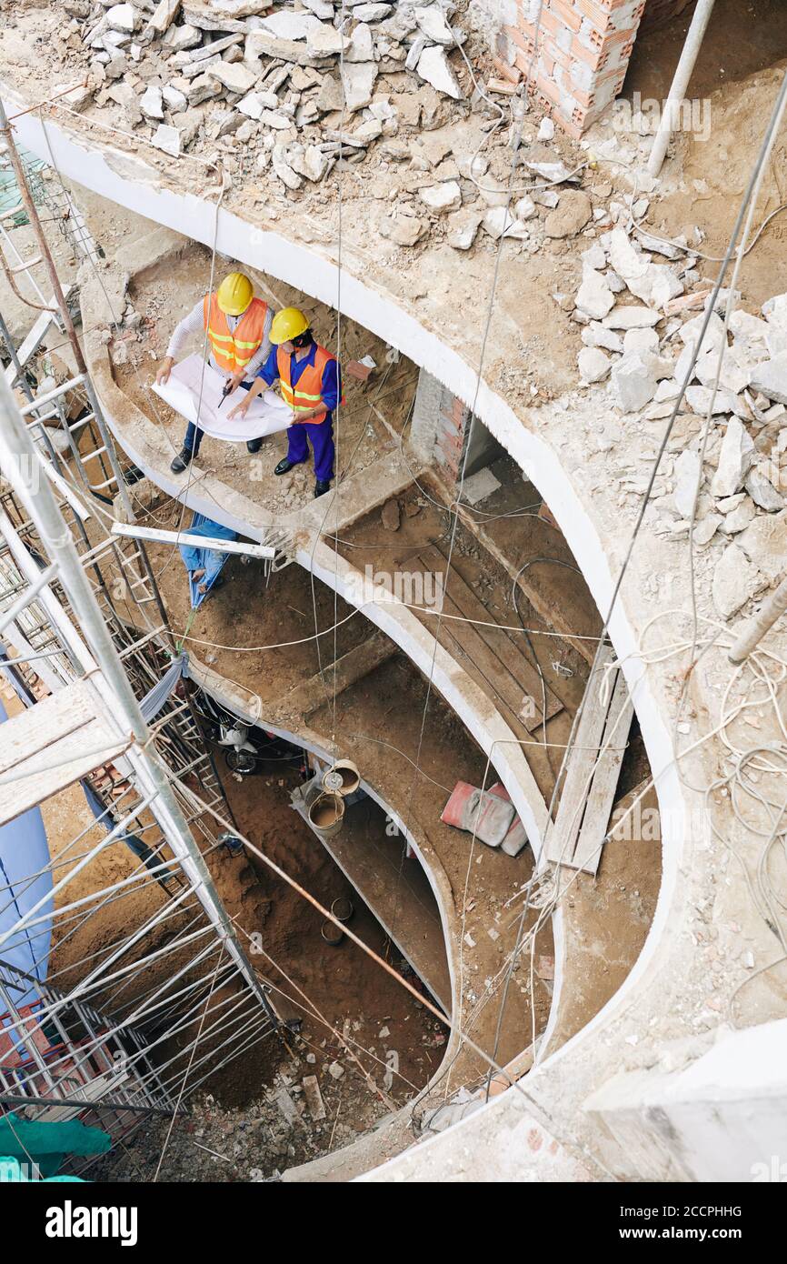 Builder showing construction blueprint to contractor when they are ...