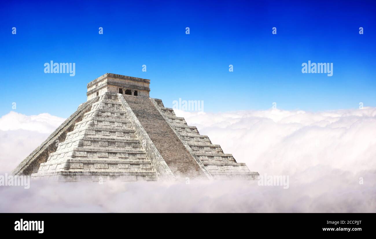 Giant Mayan Pyramid with a base hidden in the clouds. Horizontal banner with ancient pyramid of maya (Kukulcan Temple), Chichen Itza, Yucatan, Mexico. Stock Photo