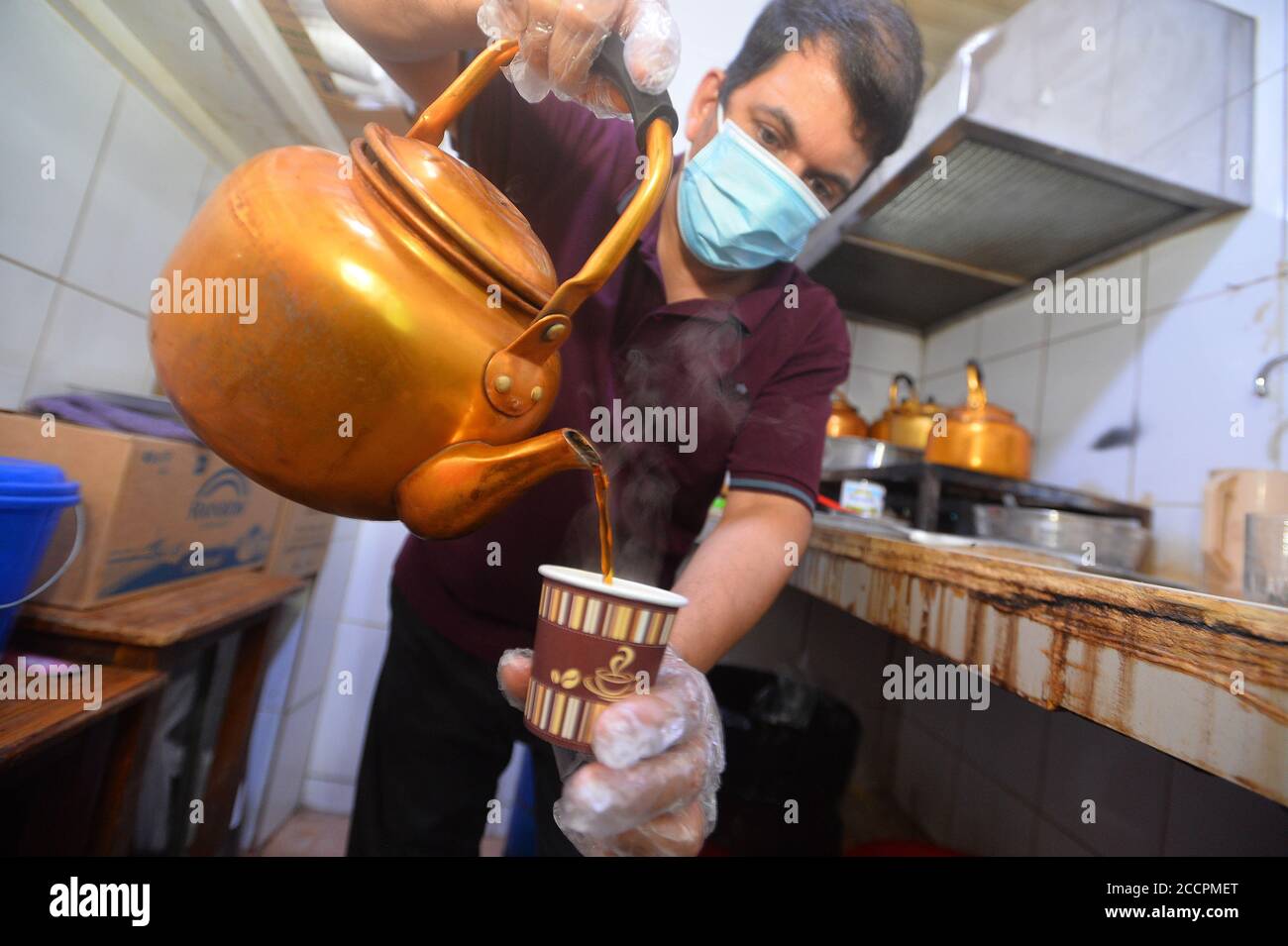 (200824) -- KUWAIT CITY, Aug. 24, 2020 (Xinhua) -- A worker prepares tea for customers at a cafe in Al-Mubarakiya market in Kuwait City, Kuwait, Aug. 23, 2020. (Photo by Asad/Xinhua) Stock Photo