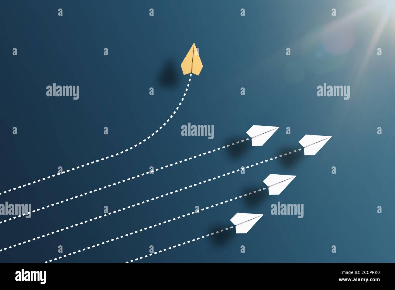 paper planes flying in formation in one direction on blue background and one paper glider going in different direction, breaking new ground and Stock Photo