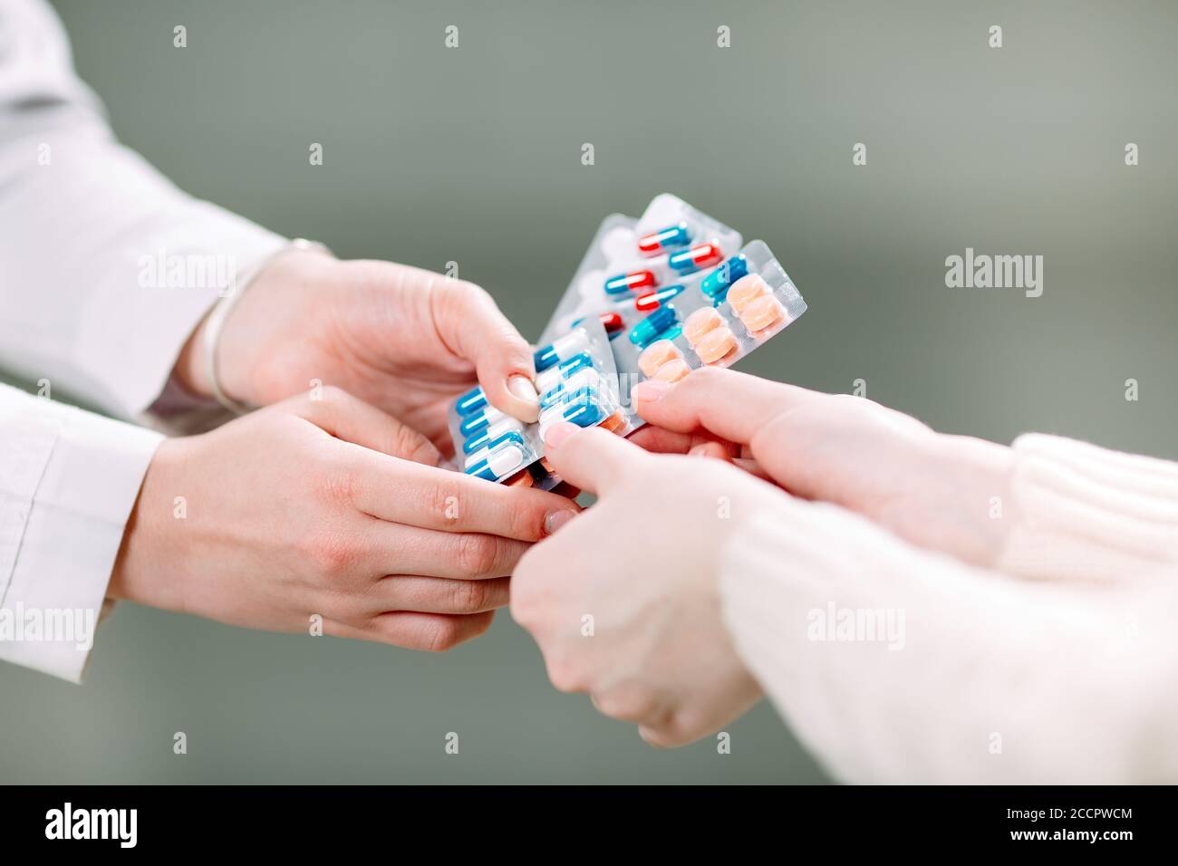 Close up of a girl hands buying pills in a pharmacy. Stock Photo