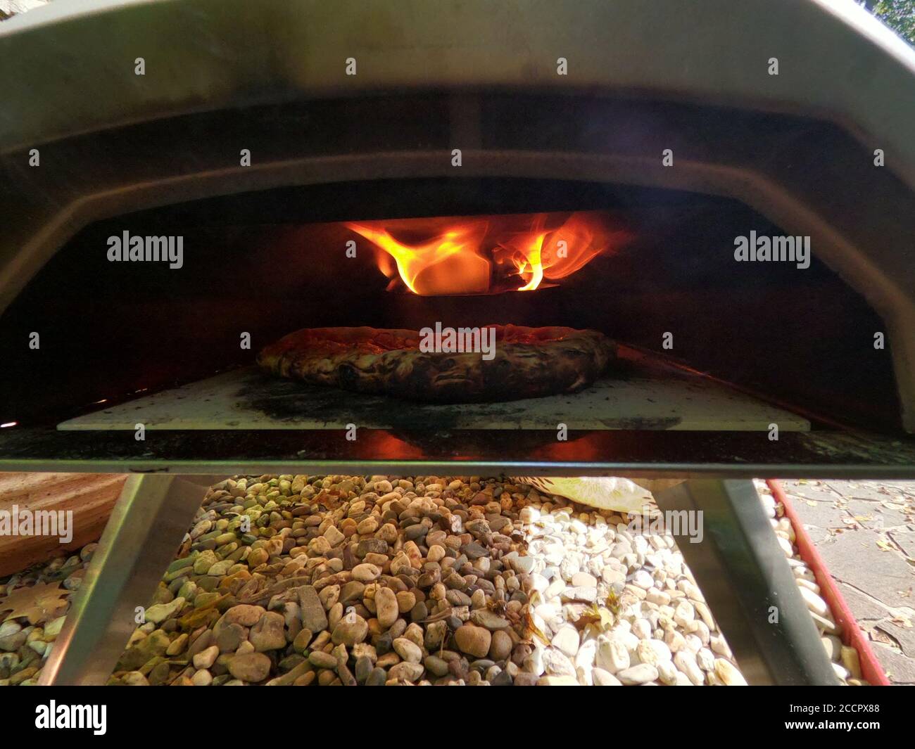 Baking Pizza in wood fired home Oven using a pizza peel Stock Photo Alamy