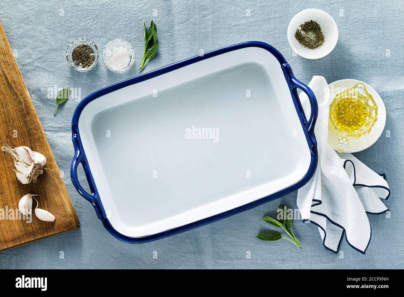 table setting with empty ceramic baking dish on a blue linen tablecloth Stock Photo