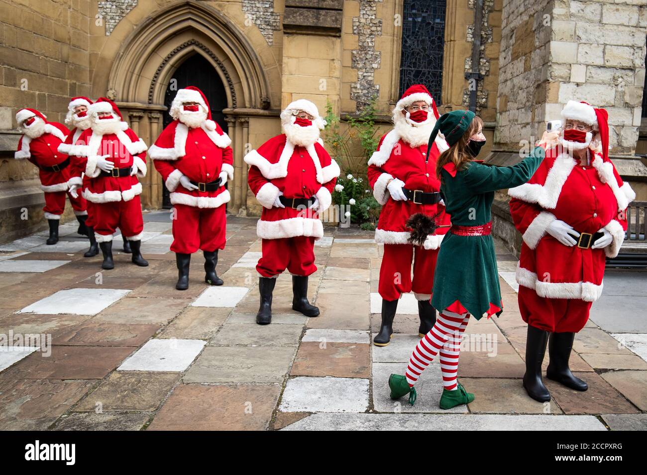 Santas at The Ministry of Fun's Summer School have their temperature taken at Southwark Cathedral, London which aims to create COVID-safe Christmas grottos by teaching Father Christmases how to appear safely in person whilst maintaining the Christmas magic. Stock Photo