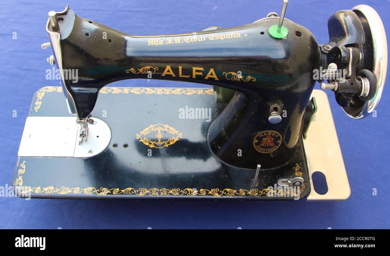 Old Alfa electric sewing machine black painted on a blue cloth background  seen from above Stock Photo - Alamy