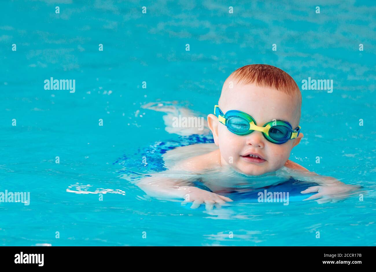 Baby boy swims independently in the pool. Stock Photo