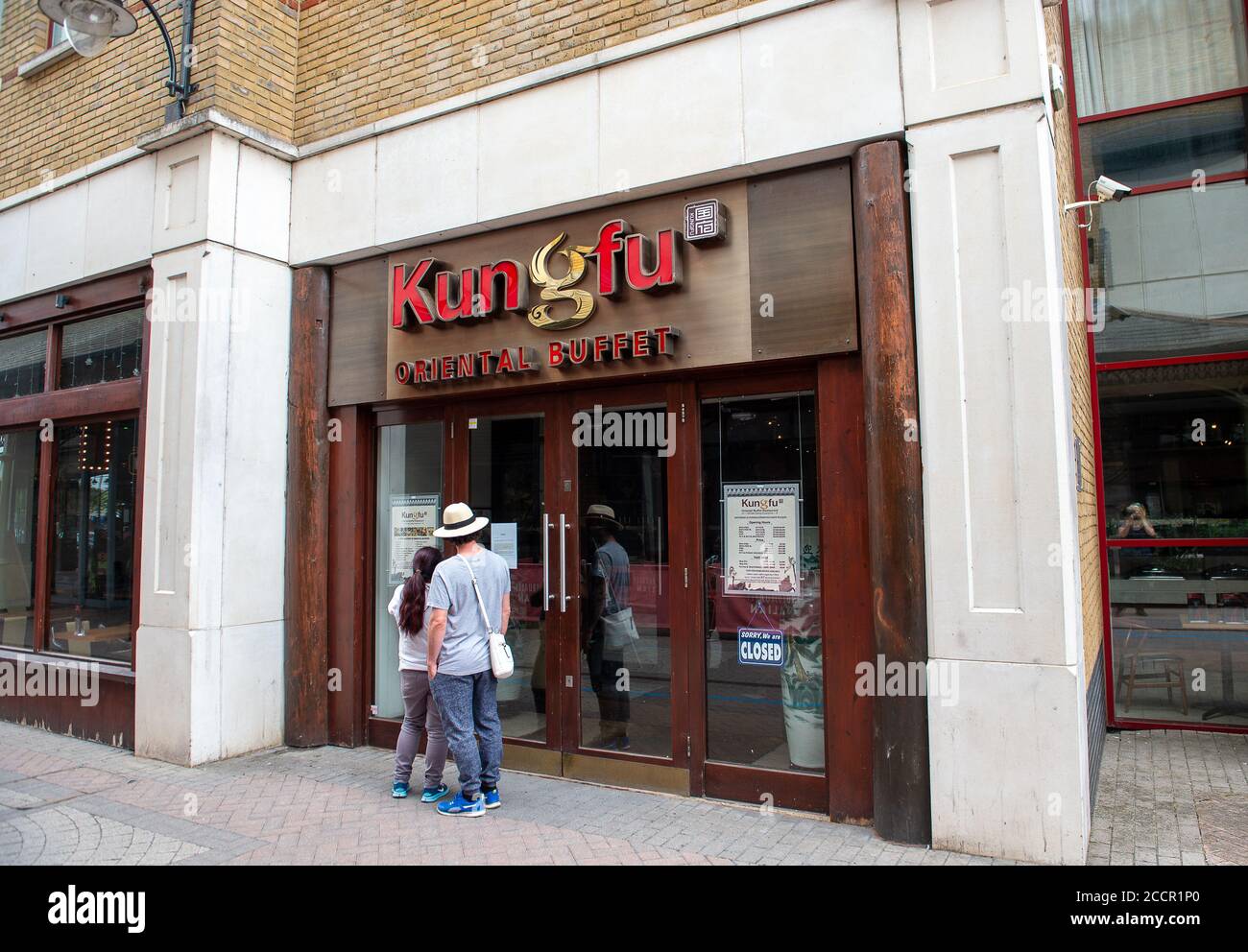 Staines-upon-Thames, Surrey, UK. 16th August, 2020. A couple read the closed notice at the Kung Fu oriental buffet restaurant. A number of restaurants that serve buffets remain closed following the Coronavirus Pandemic. Credit: Maureen McLean/Alamy Stock Photo