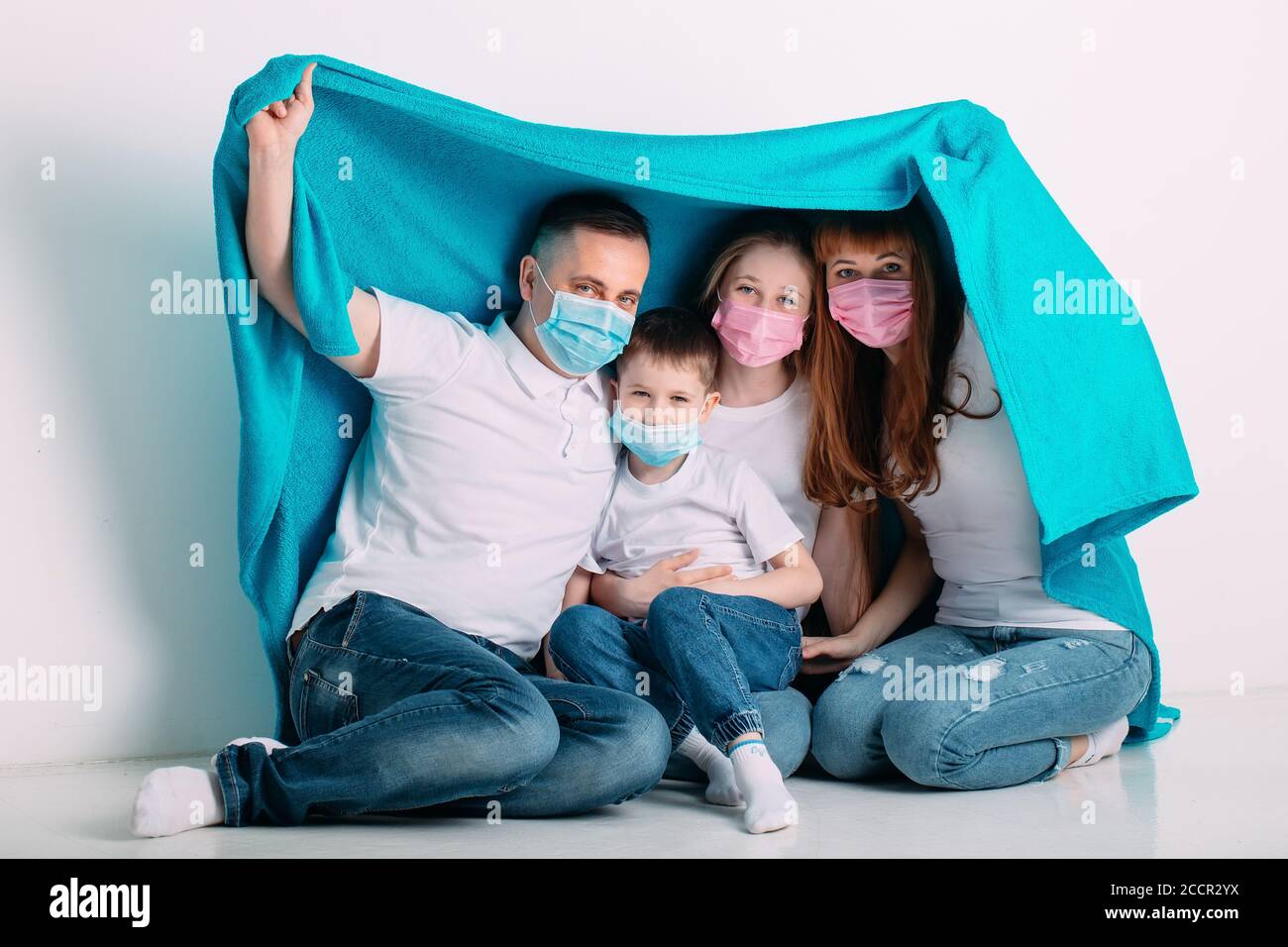 young family in medical masks during home quarantine Stock Photo - Alamy