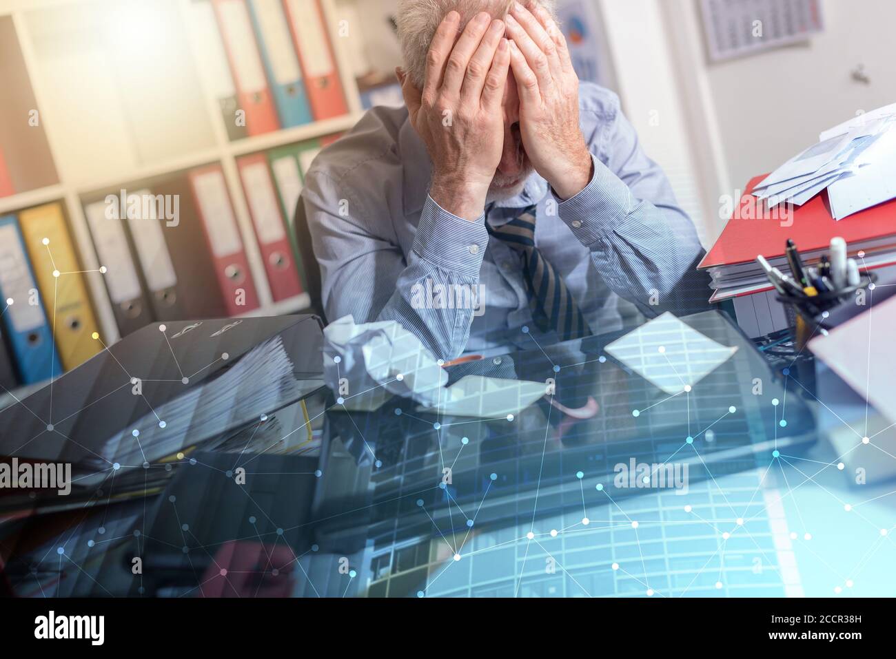 Overworked businessman sitting at a messy desk in office; multiple ...
