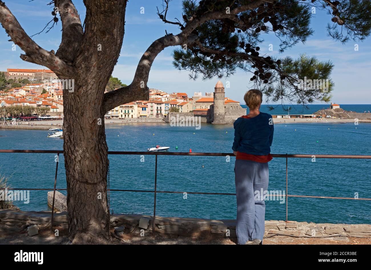 A tourist enjoys views at the harbour of Collioure in the south of France Stock Photo