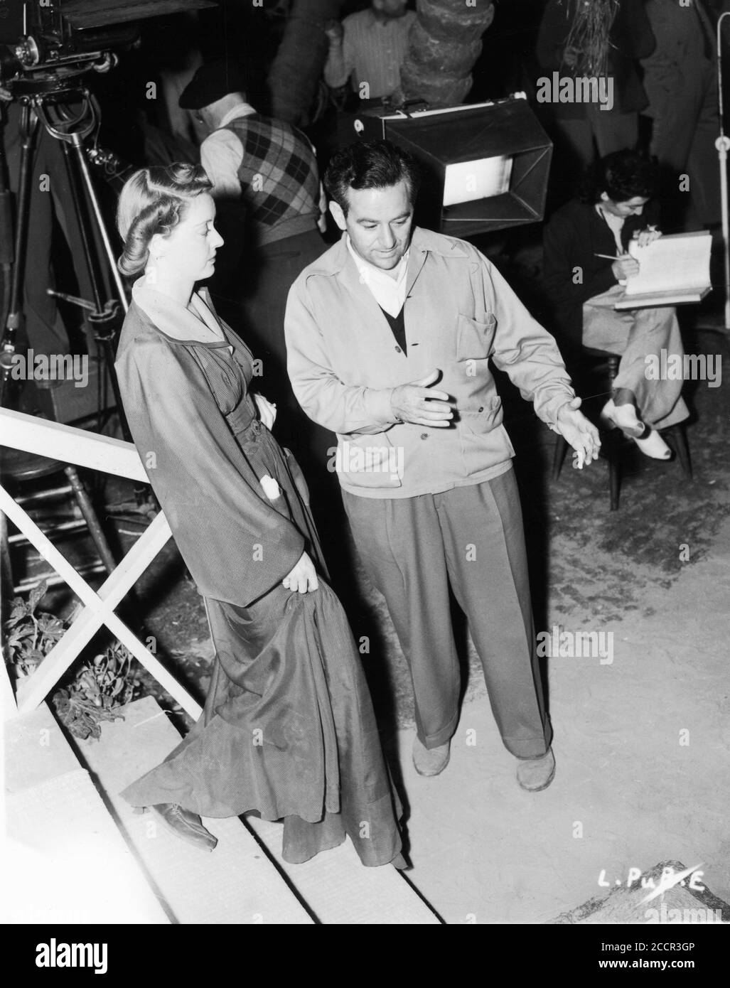 BETTE DAVIS and Director WILLIAM WYLER on set candid during filming of THE LETTER 1940 play W. Somerset Maugham screenplay Howard Koch Warner Bros. Stock Photo