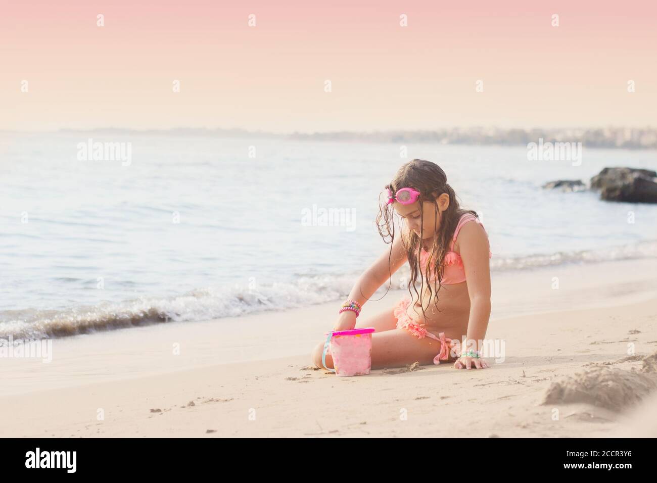 Little girl playing on the beach, making sand castle; summer and vacation Stock Photo
