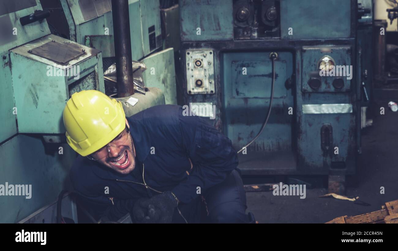 Factory worker injured by accident while using machine in factory Stock