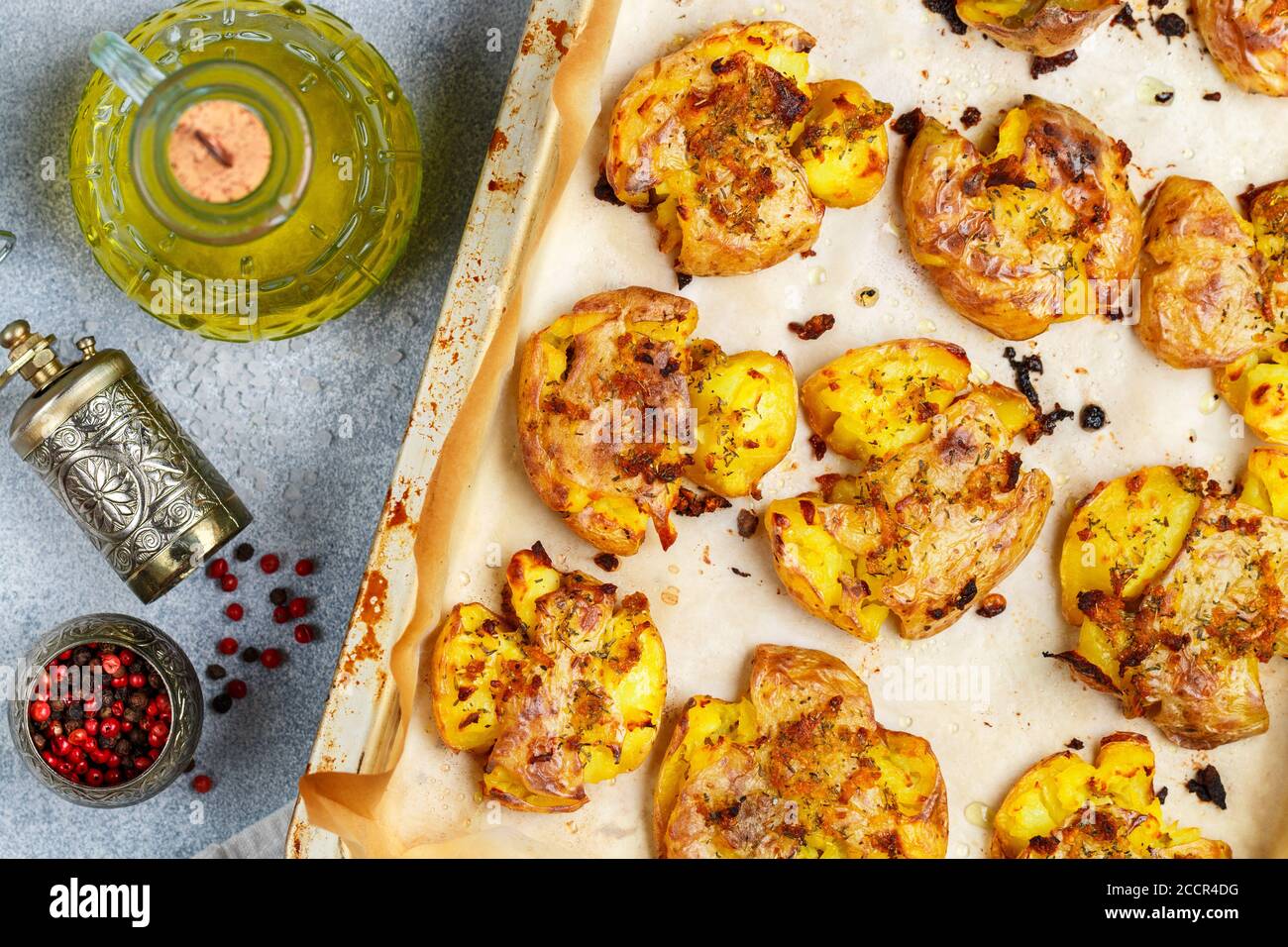 Oven baked whole crushed and crusty potato with coarse sea salt, olive