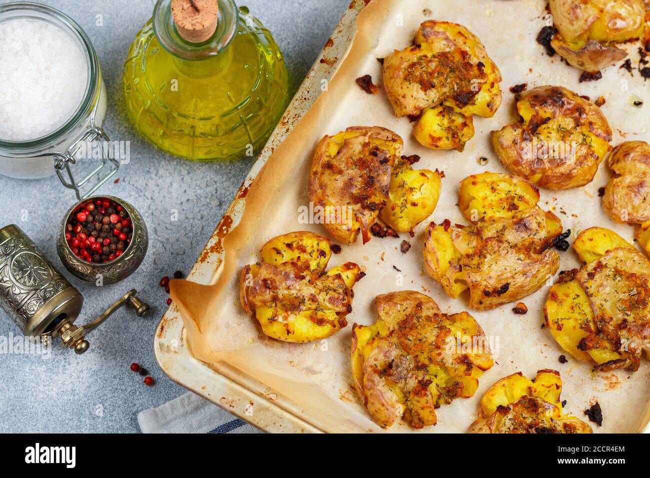 Oven baked whole crushed and crusty potato with coarse sea salt, olive