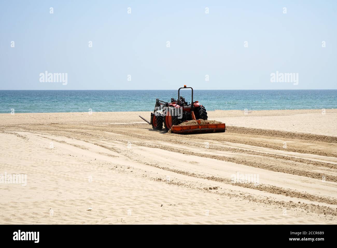 Closeup of a tractor on the beach, preparing the beach for the summer ...