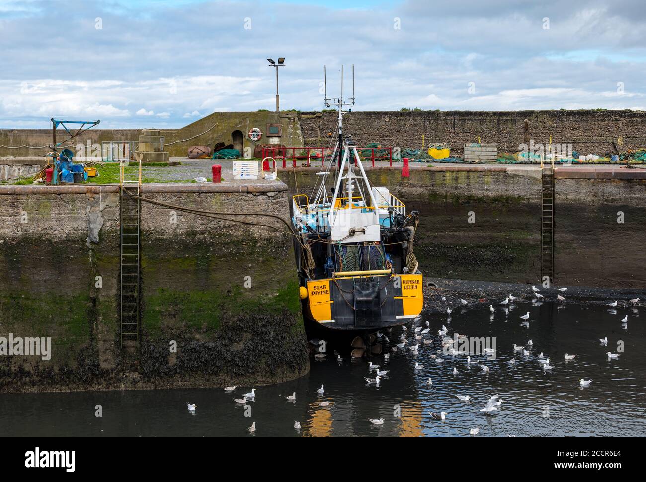 Cockenzie, East Lothian, Scotland, United Kingdom, 24th August 2020. UK Weather: The sky brightens in Port Seton harbour after a rainy morning with fishing boats aground in the mud at low tide Stock Photo