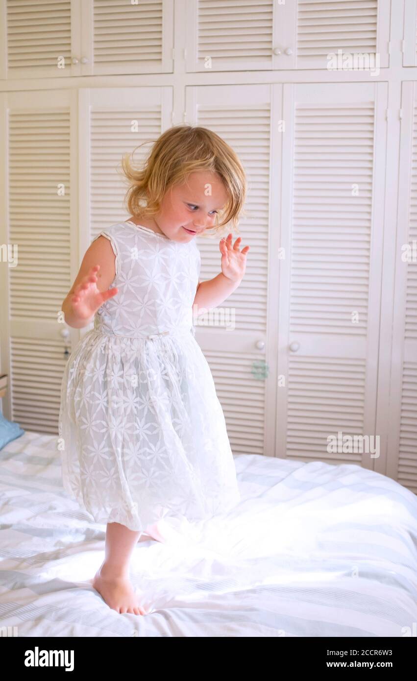 Young child female 3 years old dressing up in an old bridesmaid dress  originally worn by her grandmother 56 years earlier Stock Photo - Alamy