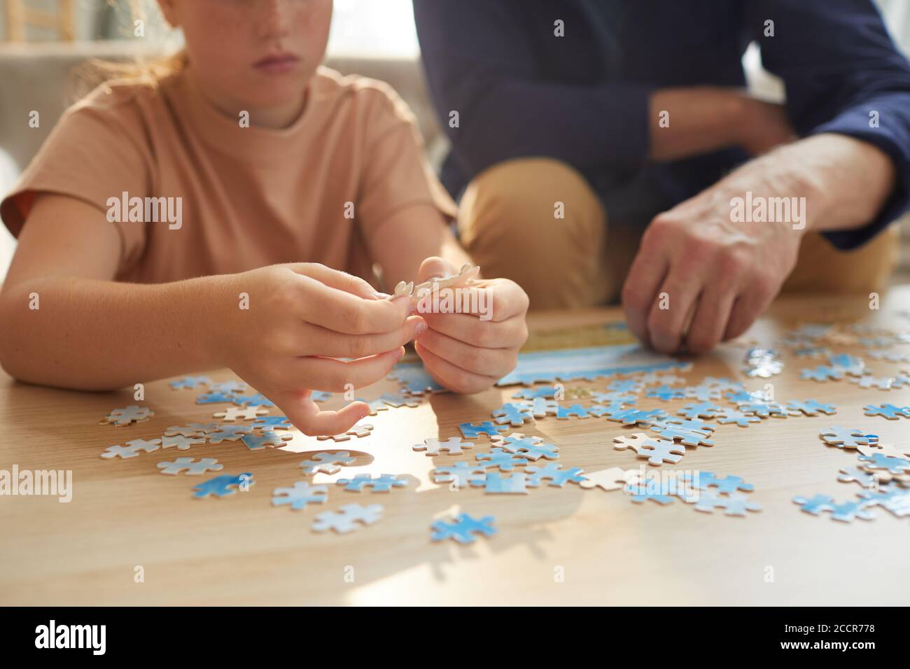 Warm toned close up of unrecognizable girl playing board games with grandparents while enjoying time together, copy space Stock Photo