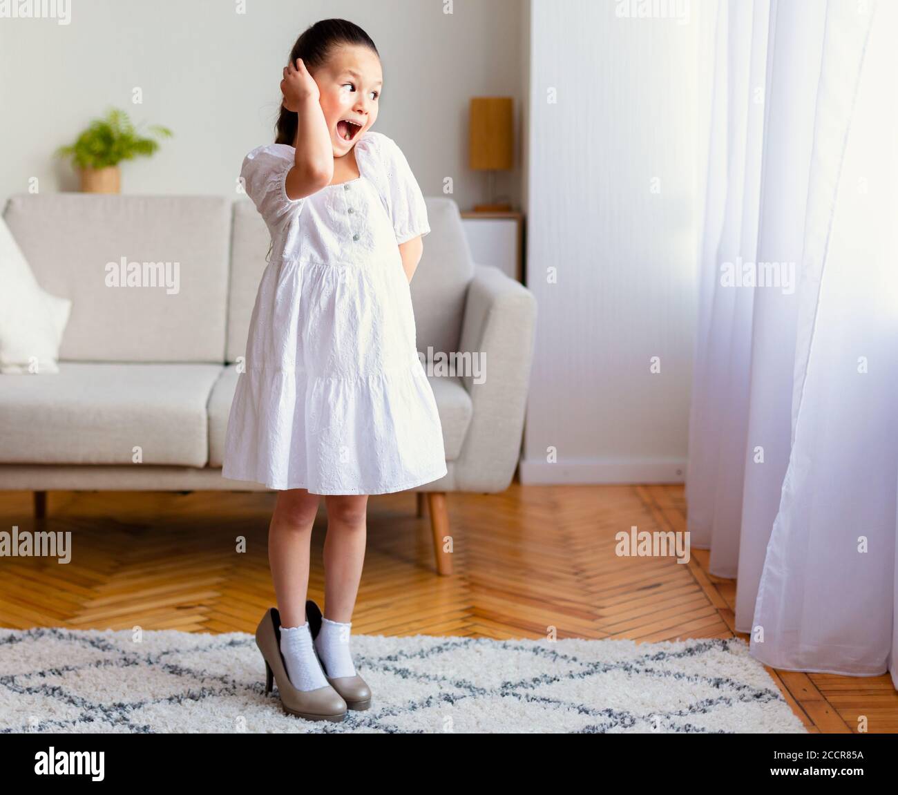 Little Girl Having Fun Wearing Mom's High Heels At Home Stock Photo - Alamy