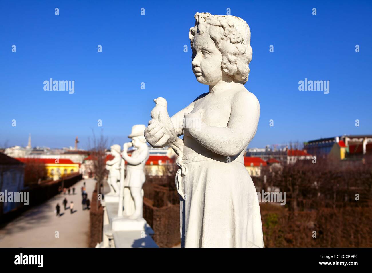 Statue of a girl with bird in the hand . Row of sculptures in the Belvedere Park in Vienne . Stock Photo