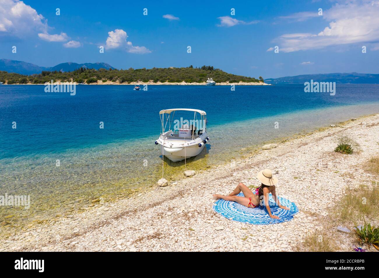 A girl in a bikini reclining on Fanari Beach, Meganissi, Ionian Islands