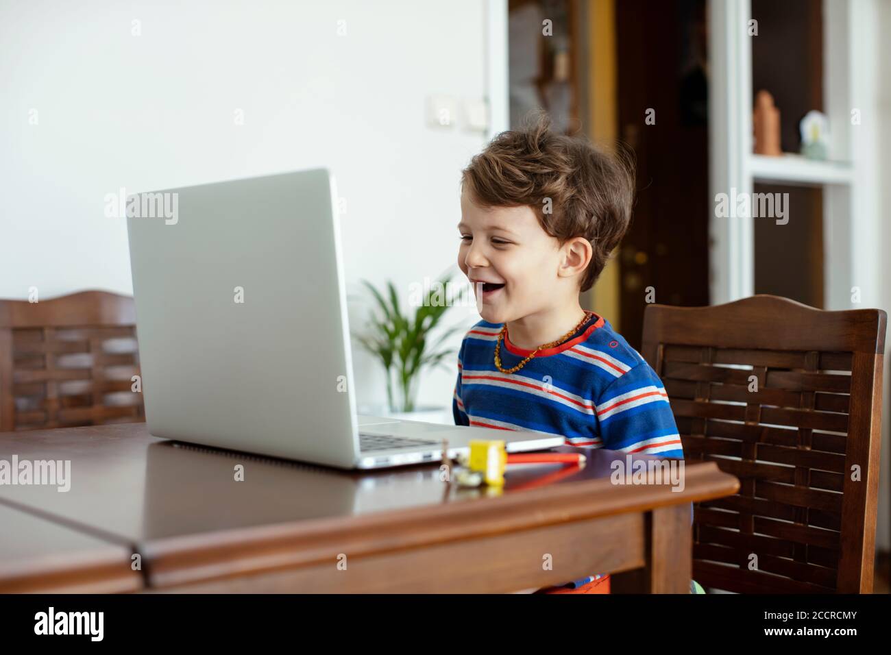 Little Child Smiling and Staring at the Computer during an Online Chat ...