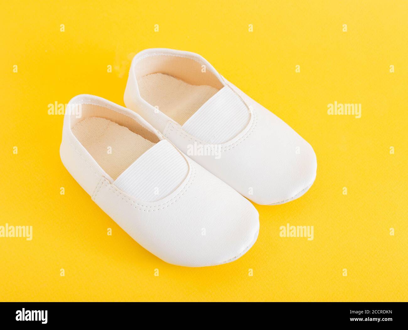 White gym shoes for children on a yellow background. Concepts for  comfortable and light indoor shoes and sports Stock Photo - Alamy