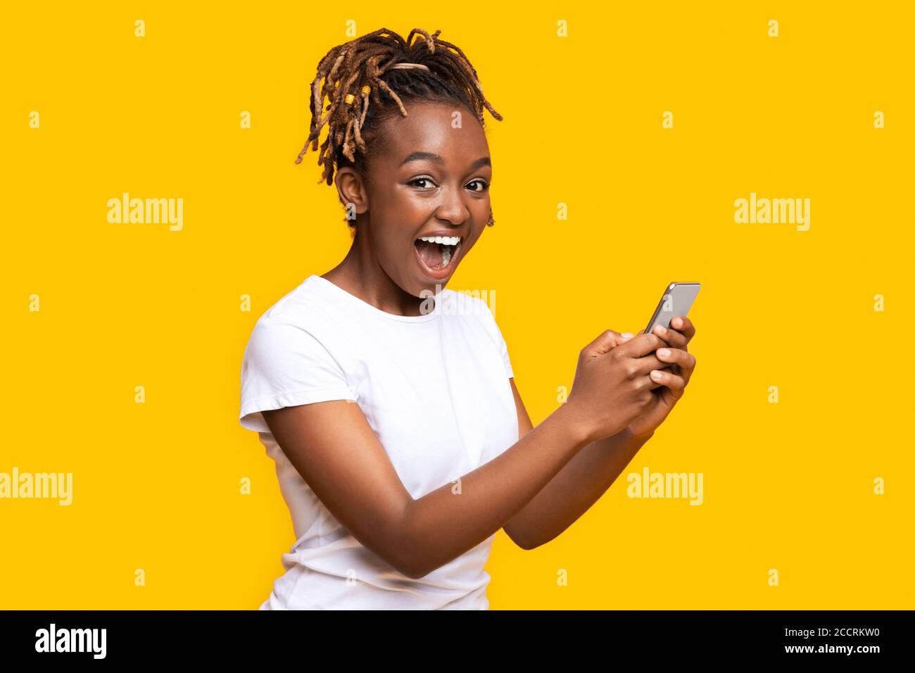 Excited black woman using mobile phone, got new nice app Stock Photo