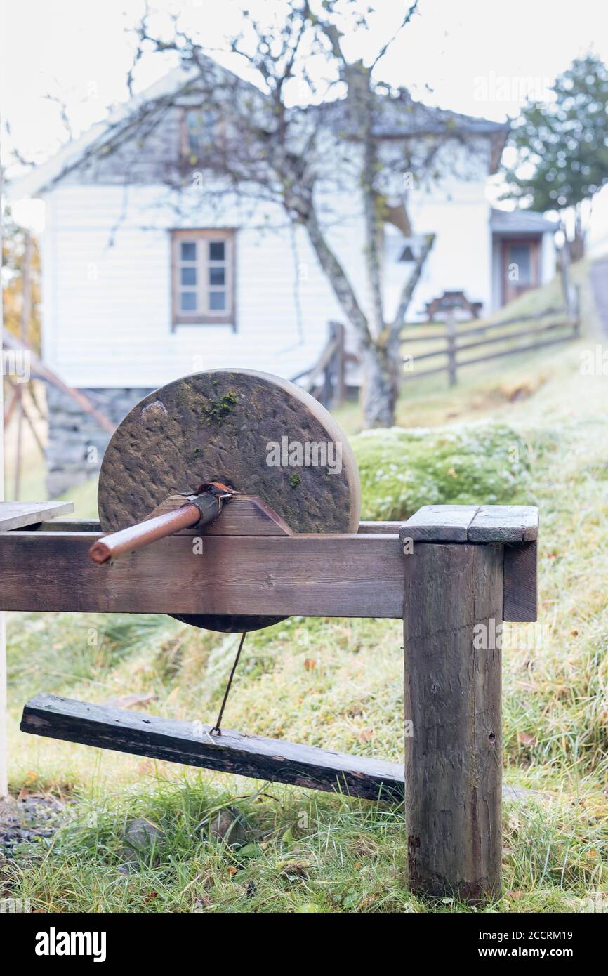 Sharpening knife on old grindstone wheel Stock Photo - Alamy