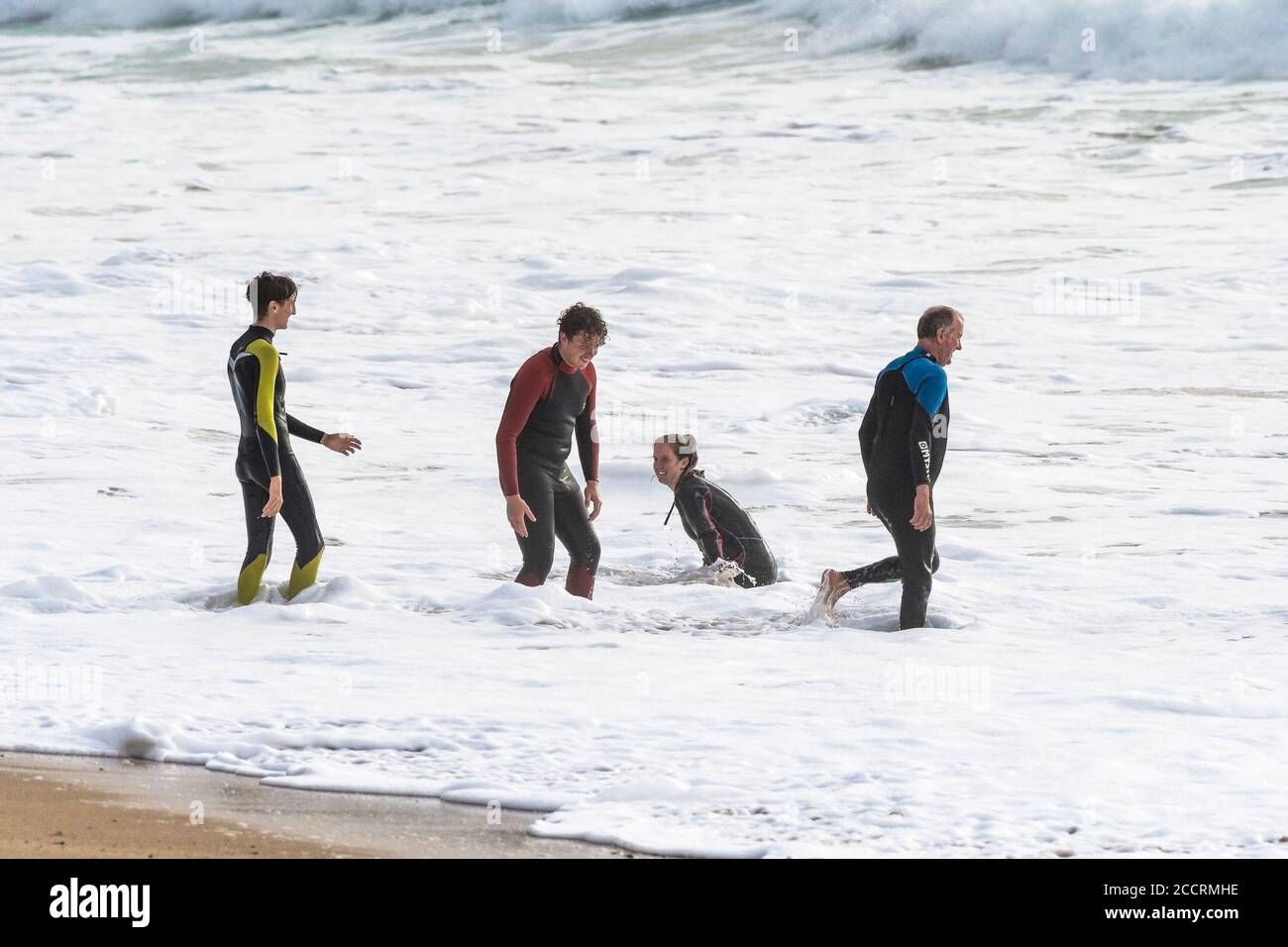Holidaymakers in wetsuits enjoying themselves in the surf on Fistral Beach in Newquay in Cornwall. Stock Photo