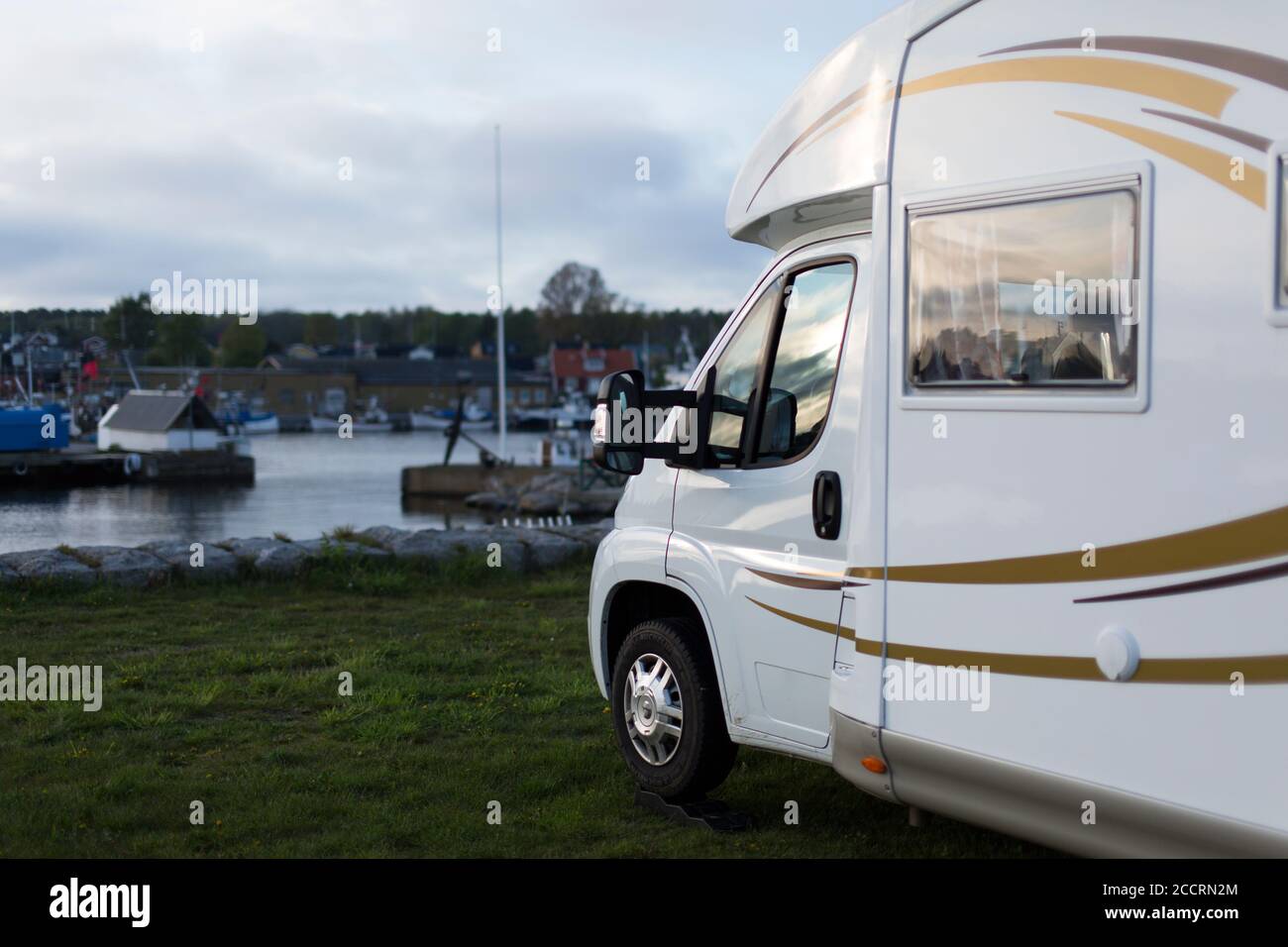 Front of a motorhome parked at a campground in the evening. Stock Photo