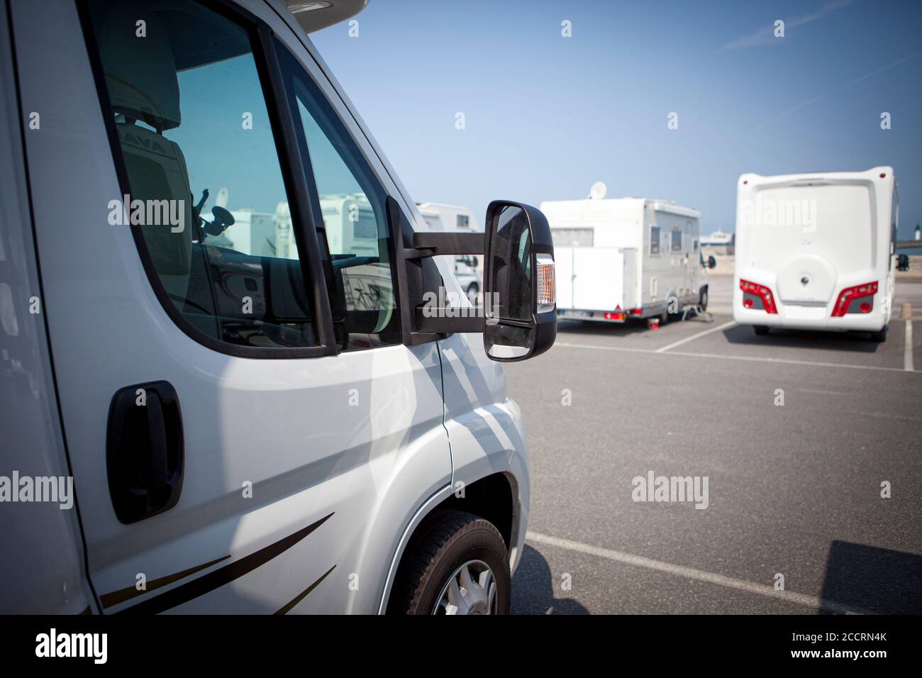 Front of a motorhome with several motorhomes parked in background. Stock Photo