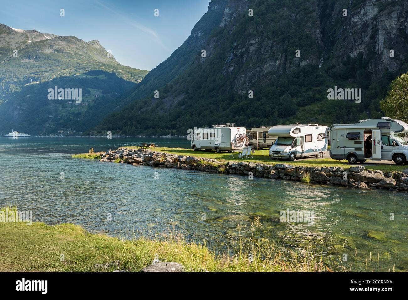 THE GEIRANGER FJORD, NORWAY - JULY 23, 2014: The campground and the parking for motorhomes just along the waterfront is an extremely popular target fo Stock Photo