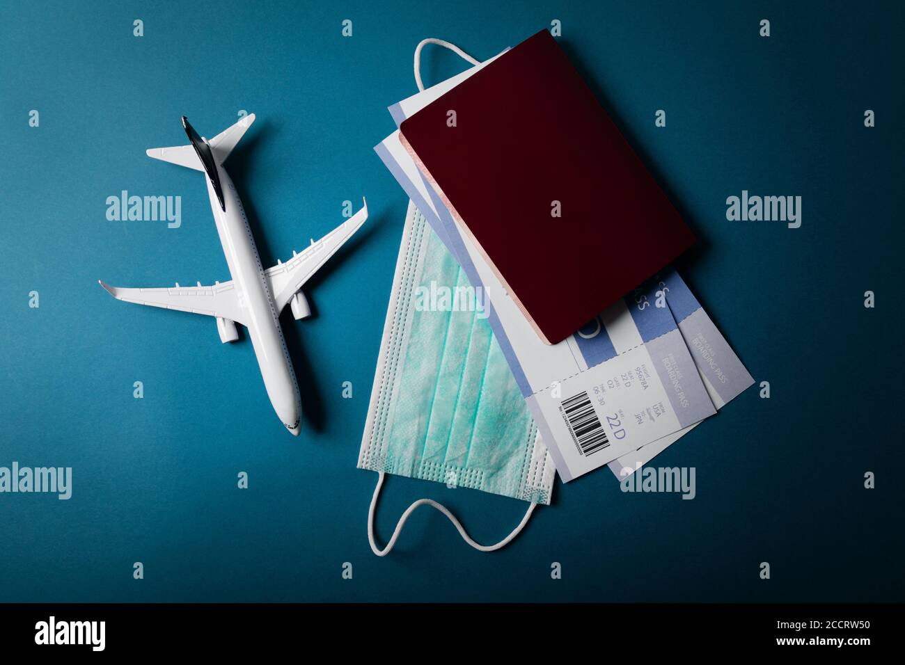 travel during the covid-19 pandemic. airplane model with face mask and travel documents Stock Photo