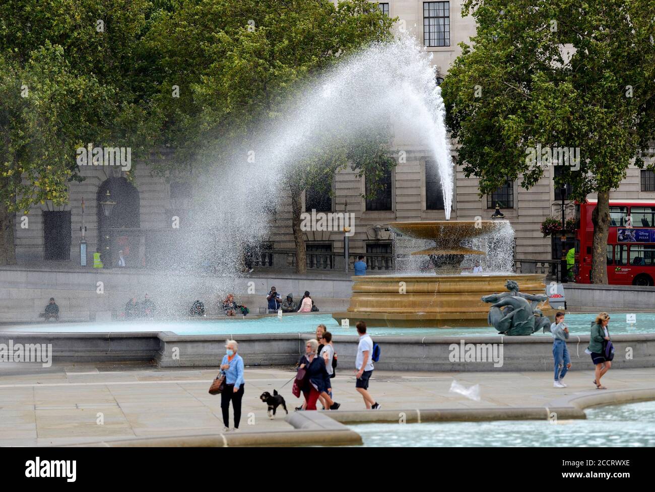 London, England, UK. Trafalgar Square - the water of one of the fountains blown across the square by strong gusting winds, August 2020 Stock Photo