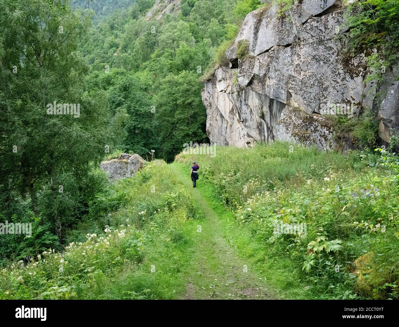 Walker on the dramatic Kongevegen - the King's Trail near Galdane now a hiking path but formerly the main route linking Laerdal and Valdres in Norway Stock Photo