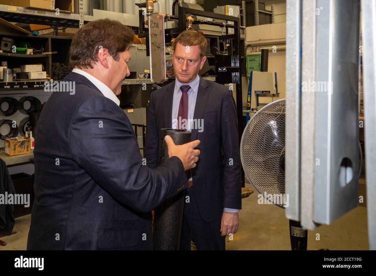 Hoyerswerda, Germany. 24th Aug, 2020. Saxony's Prime Minister Michael Kretschmer (CDU, r) in conversation with Jörg Wolf, Managing Director of Yados GmbH, in the assembly hall. The Prime Minister visits Yados GmbH in Hoyerswerda. Here he informed himself about the company and the production of heat pumps. Credit: Daniel Schäfer/dpa-Zentralbild/dpa/Alamy Live News Stock Photo